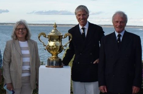 Chrissie Smyth stands beside two men, to the left of the Kings Cup trophy.